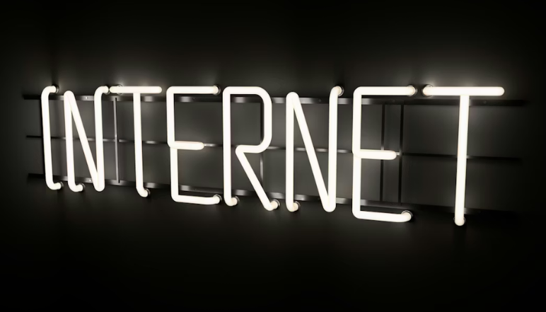 The image displays a white neon sign that spells out the word 